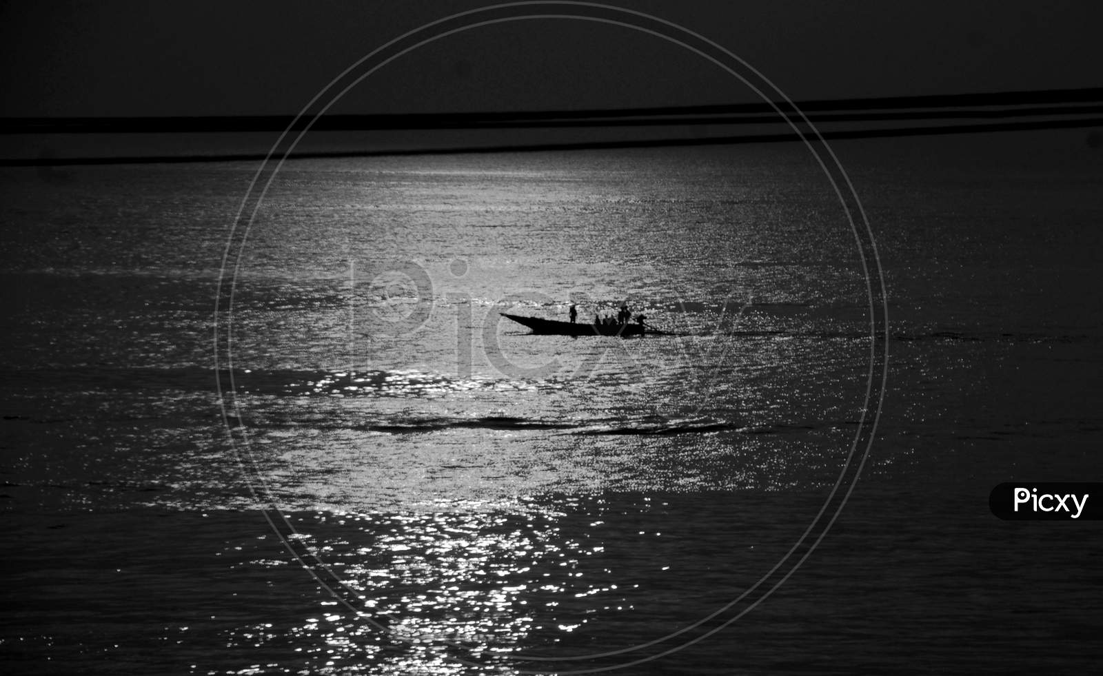 Silhouette of Fisherman Going For Fishing in Boats Over a Sea With Sunset Sky in Background