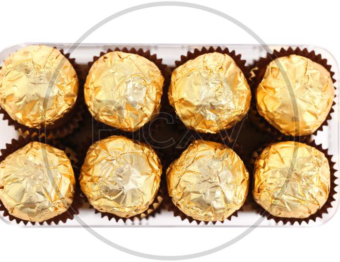 Two Rows Of Chocolate Bonbons In Box. Isolated On A White Background.