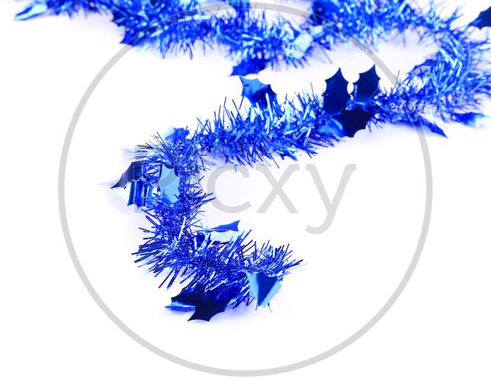 Christmas Blue Tinsel With Stars. Blurred Background.
