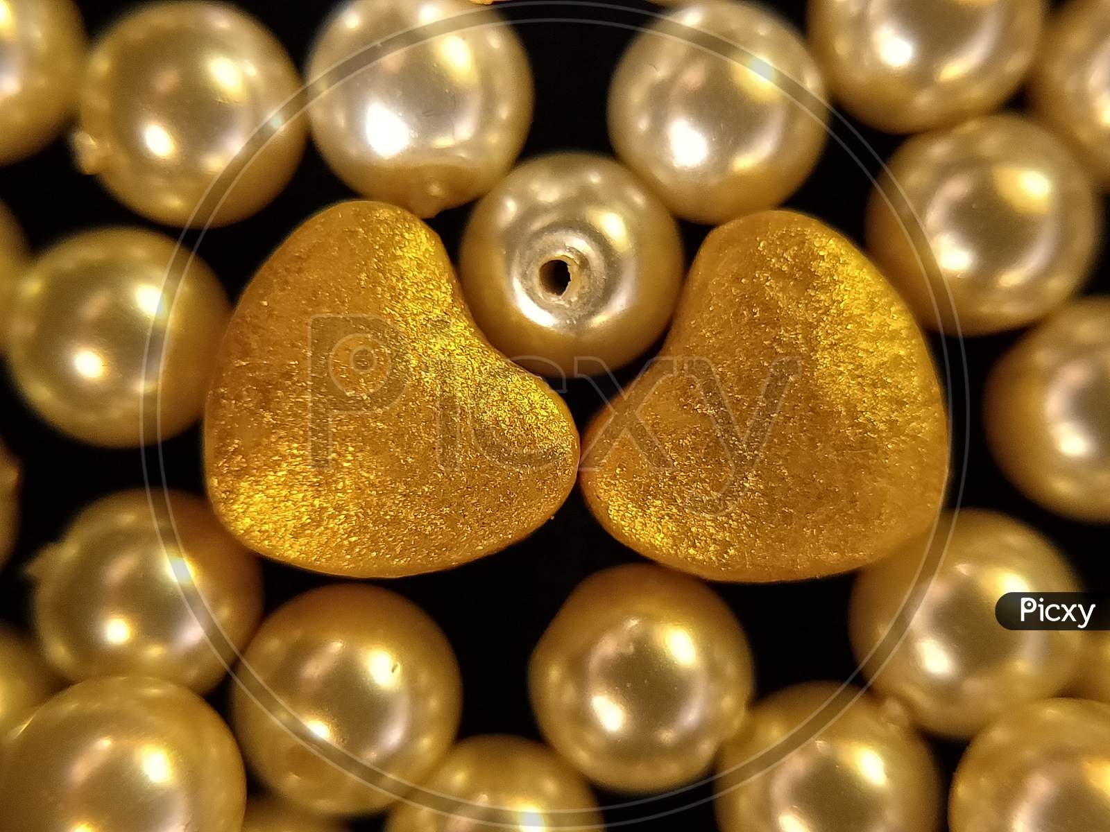 American pearls with heart shaped object. Golden hearts and pearls. Close up of pearls.