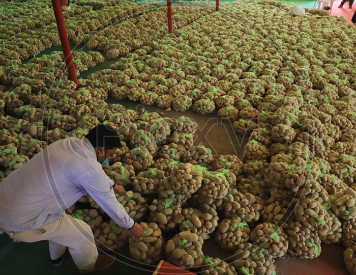 A Government Employee Picks up A Potato Packet For Distribution to Poor People During Nationwide Lockdown For  Coronavirus Disease (Covid-19), In Prayagraj, April, 14, 2020.
