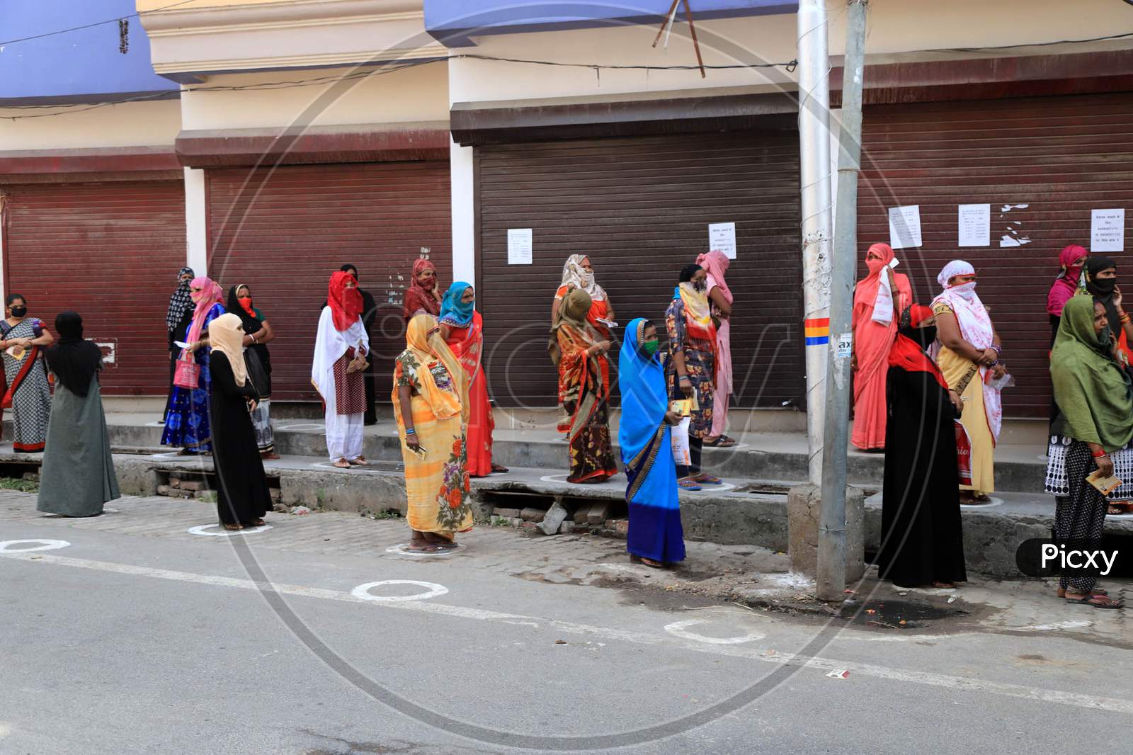 Women Standing Outside  A Bank to Withdraw Money During A Nationwide Lockdown To Slow The Spreading Of The Coronavirus Disease (Covid-19), In Prayagraj, April, 15, 2020.