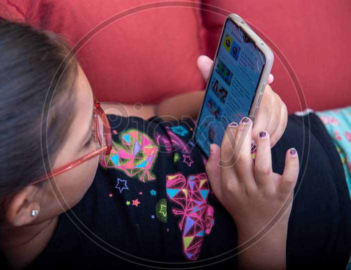 A Girl browsing through the rhymes and educational videos on mobile.