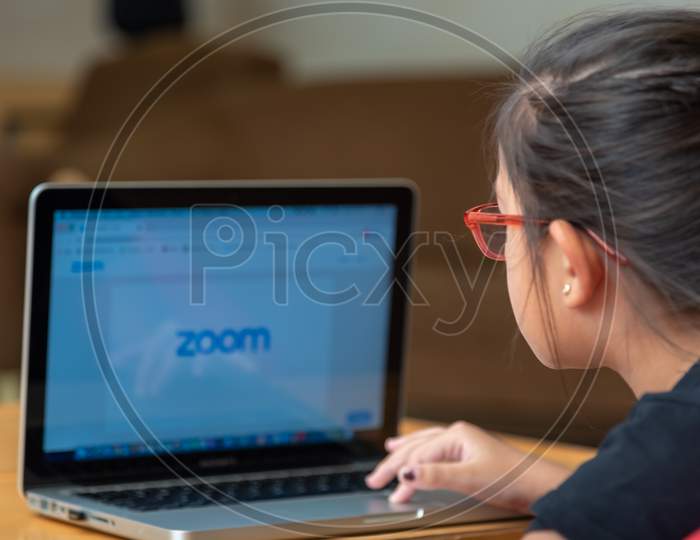 E Learning on Laptop. a girl learning on e leaning app on laptop and logging onto Zoom app. 