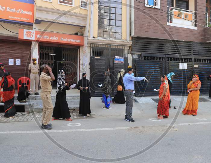 Women Standing Outside A Bank to Withdraw Money During A Nationwide Lockdown To Slow The Spreading Of The Coronavirus Disease (Covid-19), In Prayagraj, April, 15, 2020.