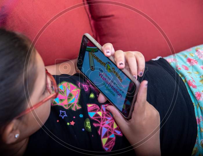 A Girl browsing through the rhymes and educational videos on mobile.