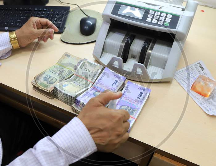 A Bank Employee Sanitizes Indian Currency Inside A Bank During A Nationwide Lock down To Slow The Spreading Of The Corona virus Disease (Covid-19), In Prayagraj, April, 15, 2020.