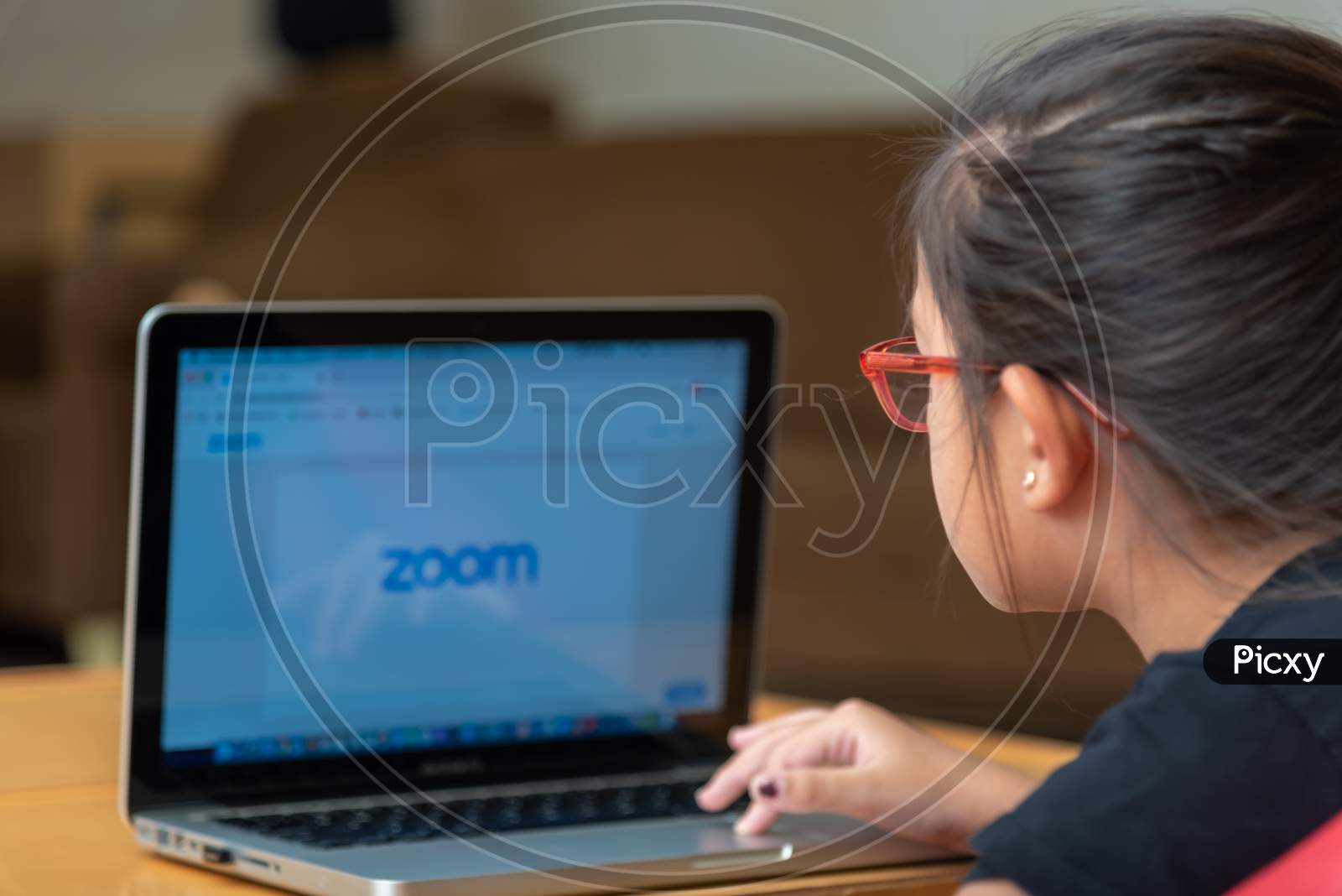 E Learning on Laptop. a girl learning on e leaning app on laptop and logging onto Zoom app. 