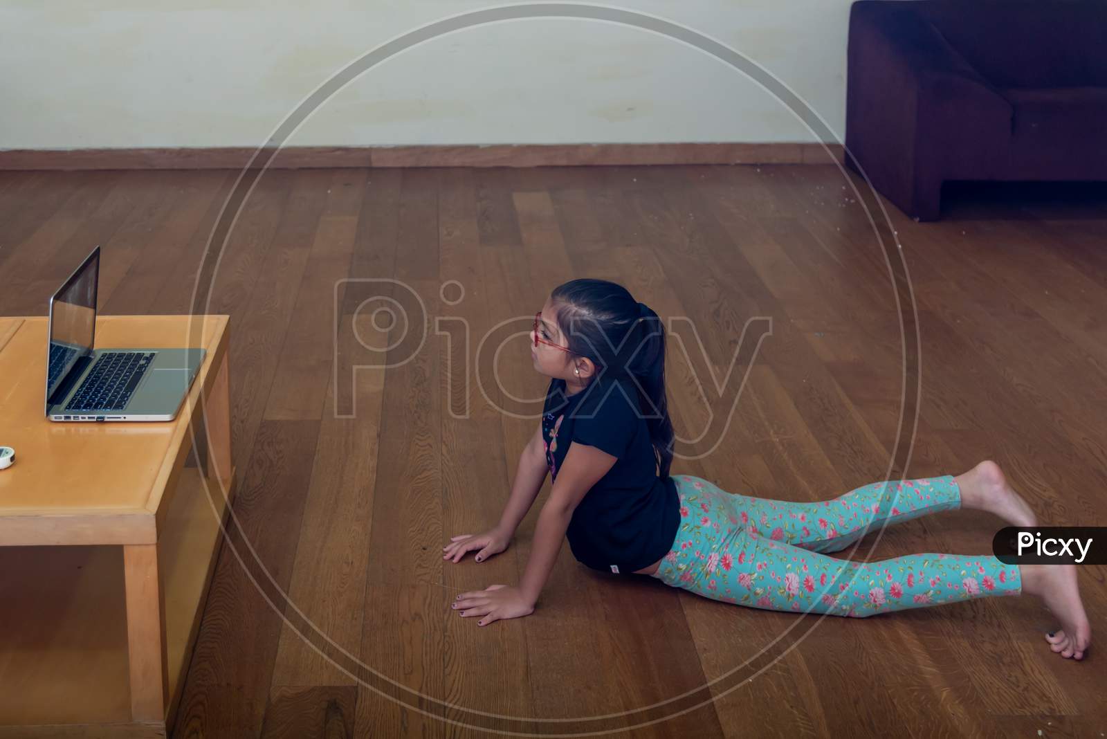 a girl performing yoga and doing meditation as instructed by her teacher through e learning platform
