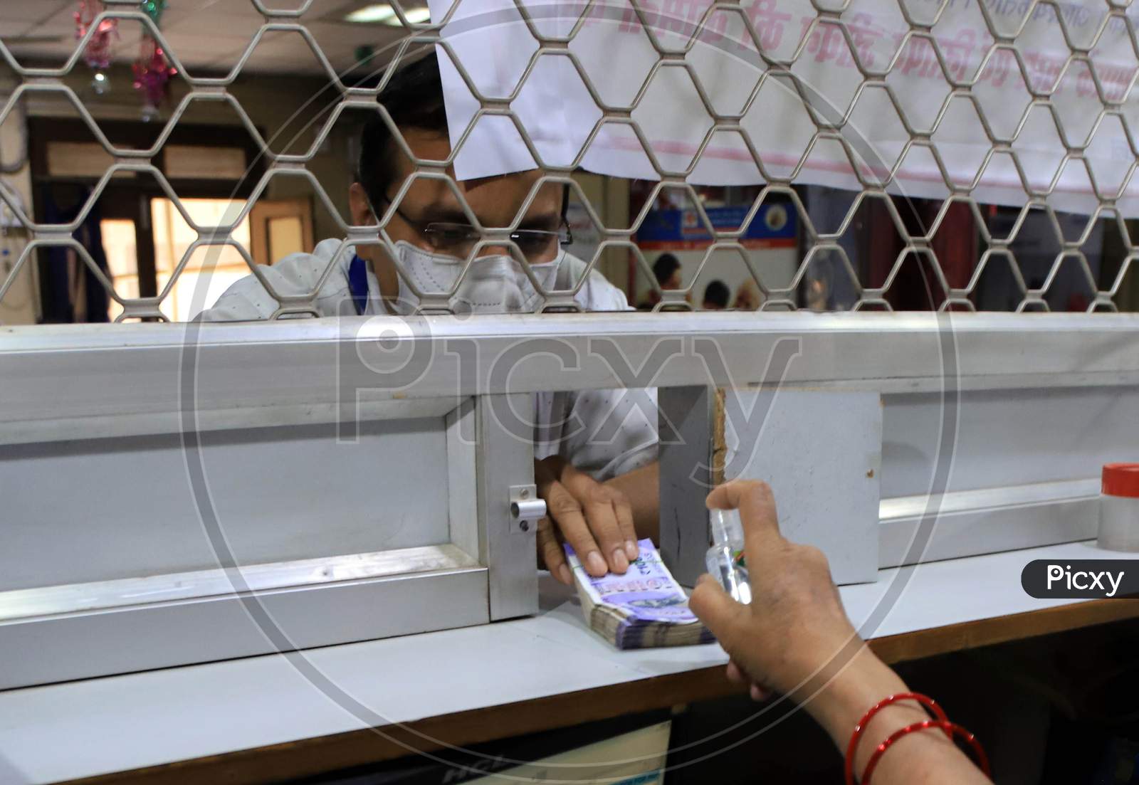 A Bank Employee Sanitizes Indian Currency Inside A Bank During A Nationwide Lock down To Slow The Spreading Of The Corona virus Disease (Covid-19), In Prayagraj, April, 16, 2020.