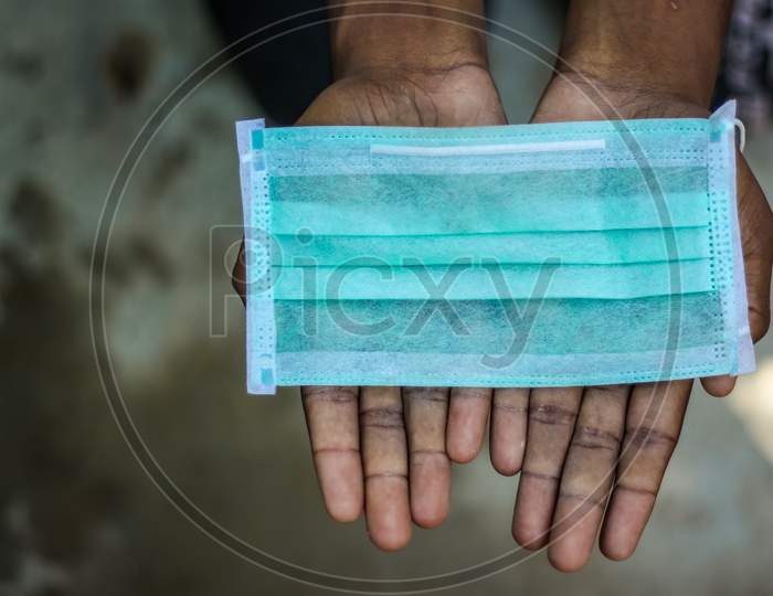Protective Face Mask In Hand. Surgical Mask. Medical Mask And Corona Virus Protection mask Isolated On A Gray Background. Face Mask on Hands