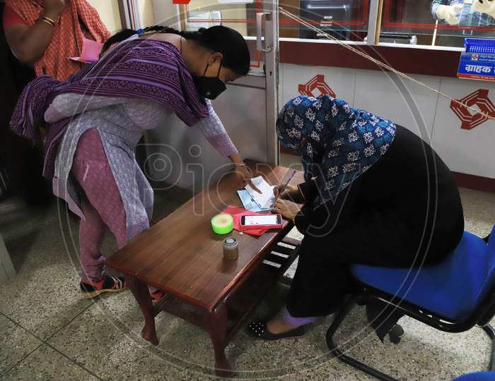 A Woman Filling Form For Withdrawal of Money Inside A Bank During A Nationwide Lock down To Slow The Spreading Of The Corona virus Disease (Covid-19), In Prayagraj, April, 16, 2020.