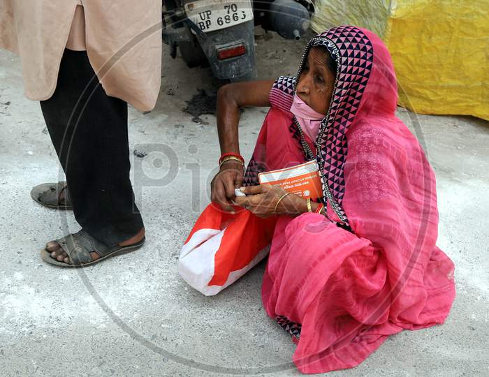 An Old Woman Sitting  In A Queue Line To Withdraw Money  Outside Of A Bank During A Nationwide Lockdown To Slow The Spreading Of The Coronavirus Disease (Covid-19), In Prayagraj, April, 16, 2020.