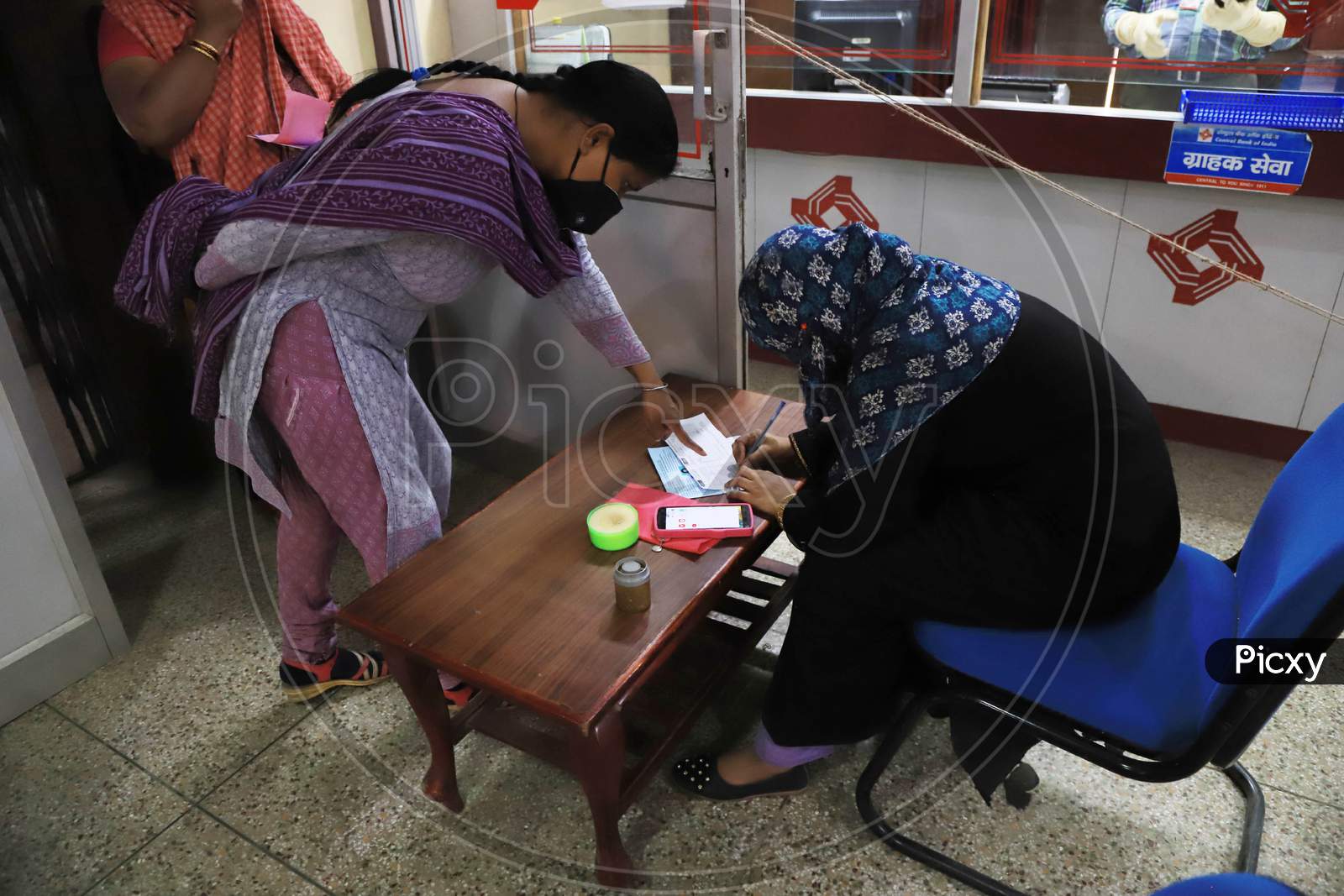 A Woman Filling Form For Withdrawal of Money Inside A Bank During A Nationwide Lock down To Slow The Spreading Of The Corona virus Disease (Covid-19), In Prayagraj, April, 16, 2020.