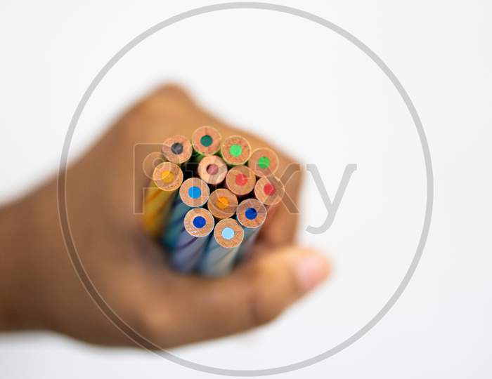 Color Pencils in a Fist On white Background Showing Unity