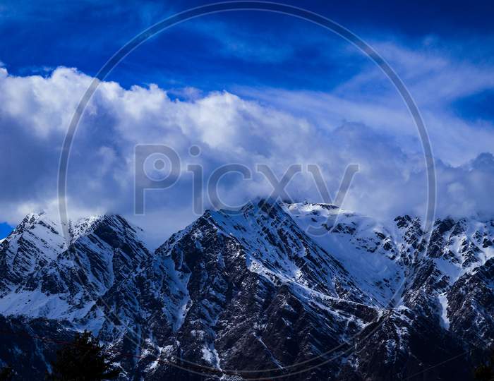 Snow covered Mountains with Blue sky and clouds in india