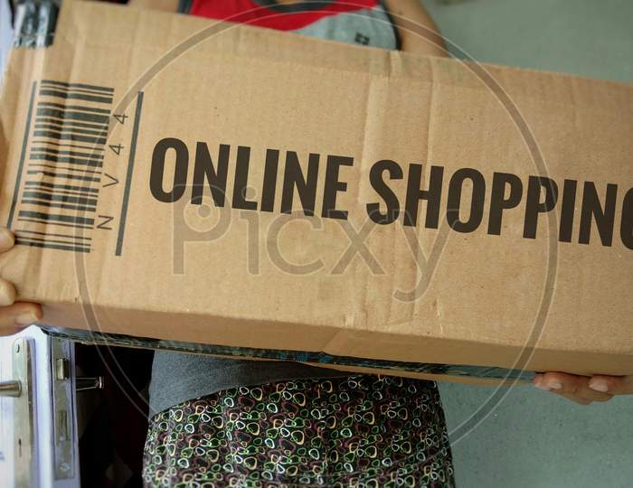 Received online shopping package, holding a cardboard box of parcel