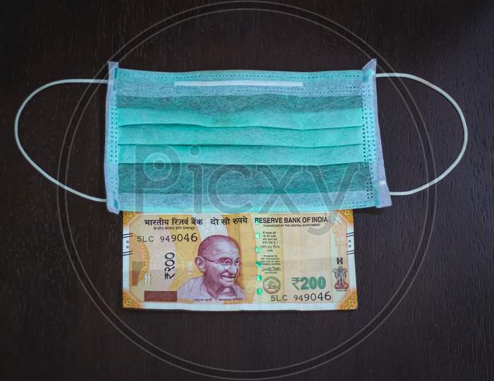 Protective Face Mask And Rupees Isolated On A Dark Background From Top View. Face Mask Are in High Demand So Rate is Increasing Day By Day
