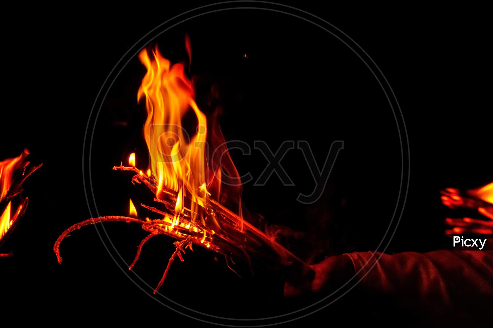 Picture of the human hand holding a flaming torch in the dark night
