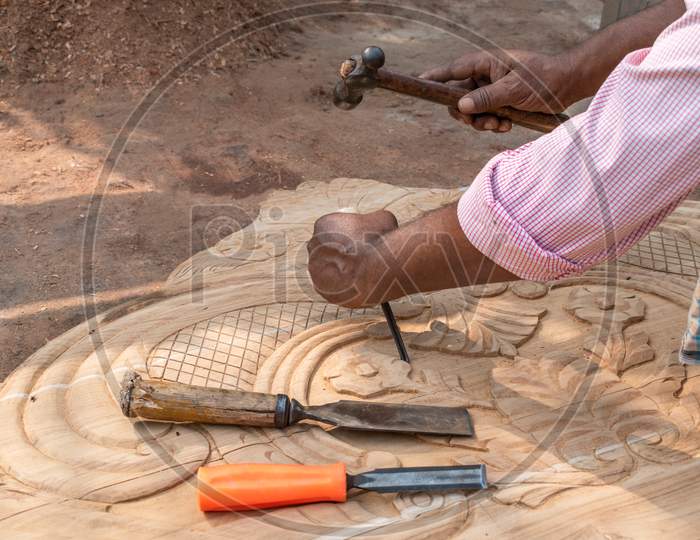 Design work on the wooden planks is underway and the hand of a carpenter