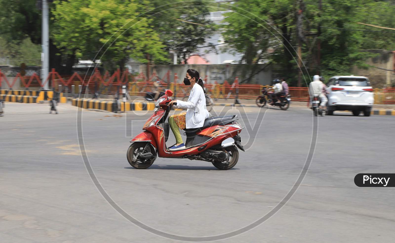 A Lady Doctor Rides Scooty On The Road During A Nationwide Lockdown To Slow The Spreading Of The Corona virus Disease (Covid-19), In Prayagraj, April, 17, 2020.