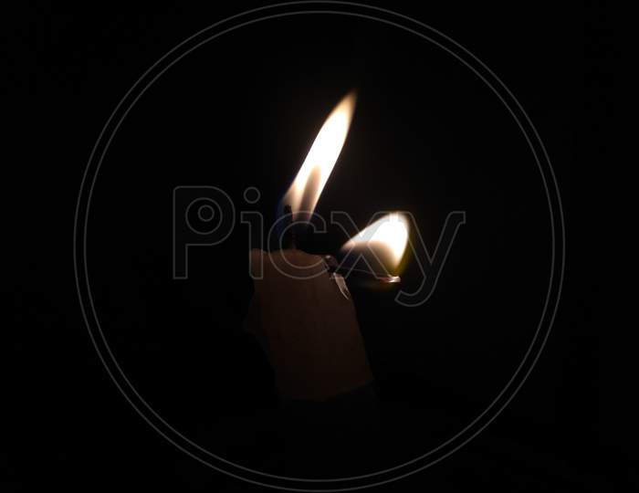 A candle with two flame on the black background