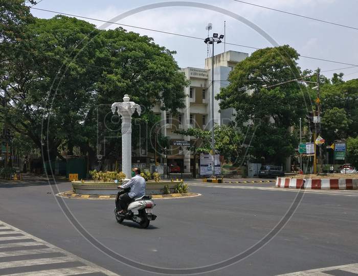 Man driving alone. Isolated street/junction  due to the Pandemic COVID-19 (Coronavirus).. Pune, Maharashtra, India