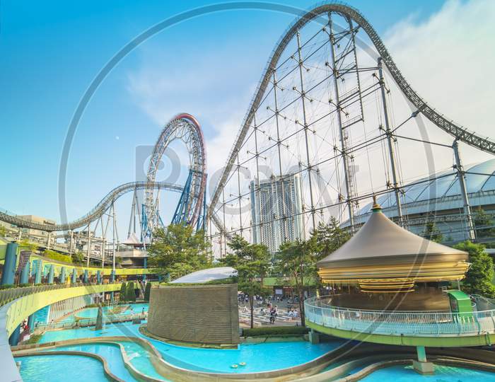 Laqua Tokyo Dome City Mall With Its Impressive Roller Coaster Integrated In The Gallery Of Its Shopping Center With A Carousel  And Water Coaster Under The Summer Blue Sky.