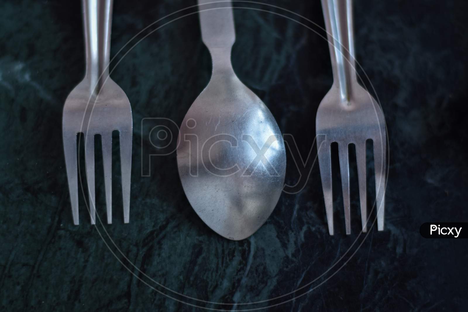 cutlery or spoon and fork over a black marble