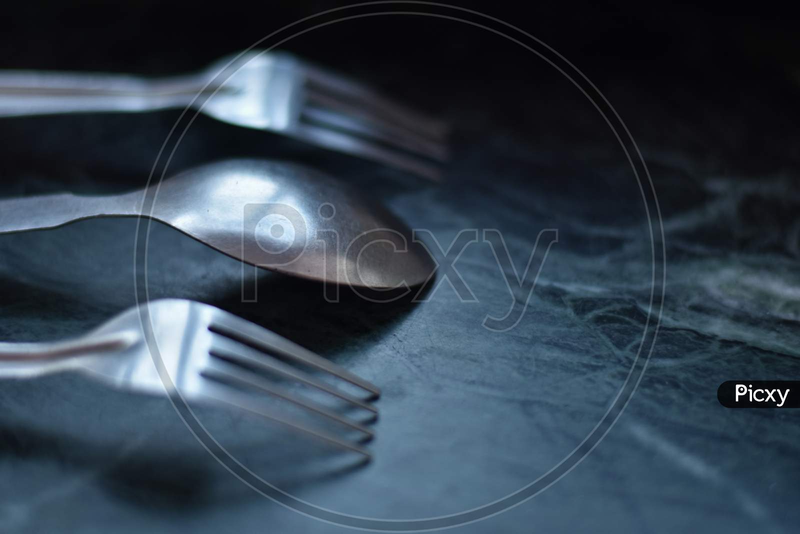 cutlery or spoon and fork over a black marble