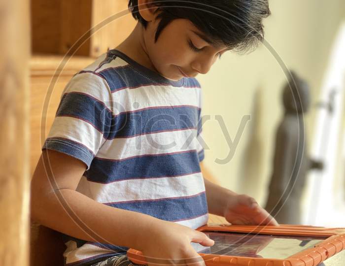 Pretty school boy studying homework math during her online lesson at home, social distance during quarantine, self-isolation, online education concept, home schooler