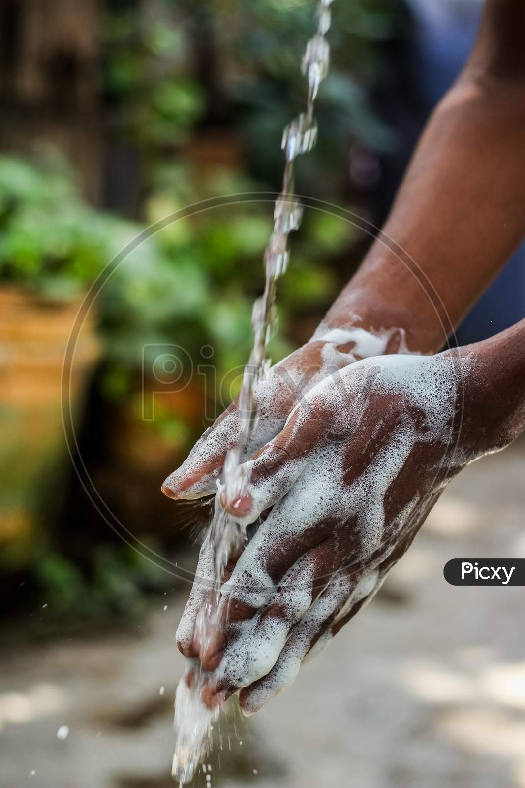 Washing Hands.Man Washing His Hands In The Garden At Home.Coronavirus Pandemic Prevention Wash Hands With Soap Warm Water And , Rubbing Nails And Fingers Washing Frequently. Hygiene & Cleaning Hands.