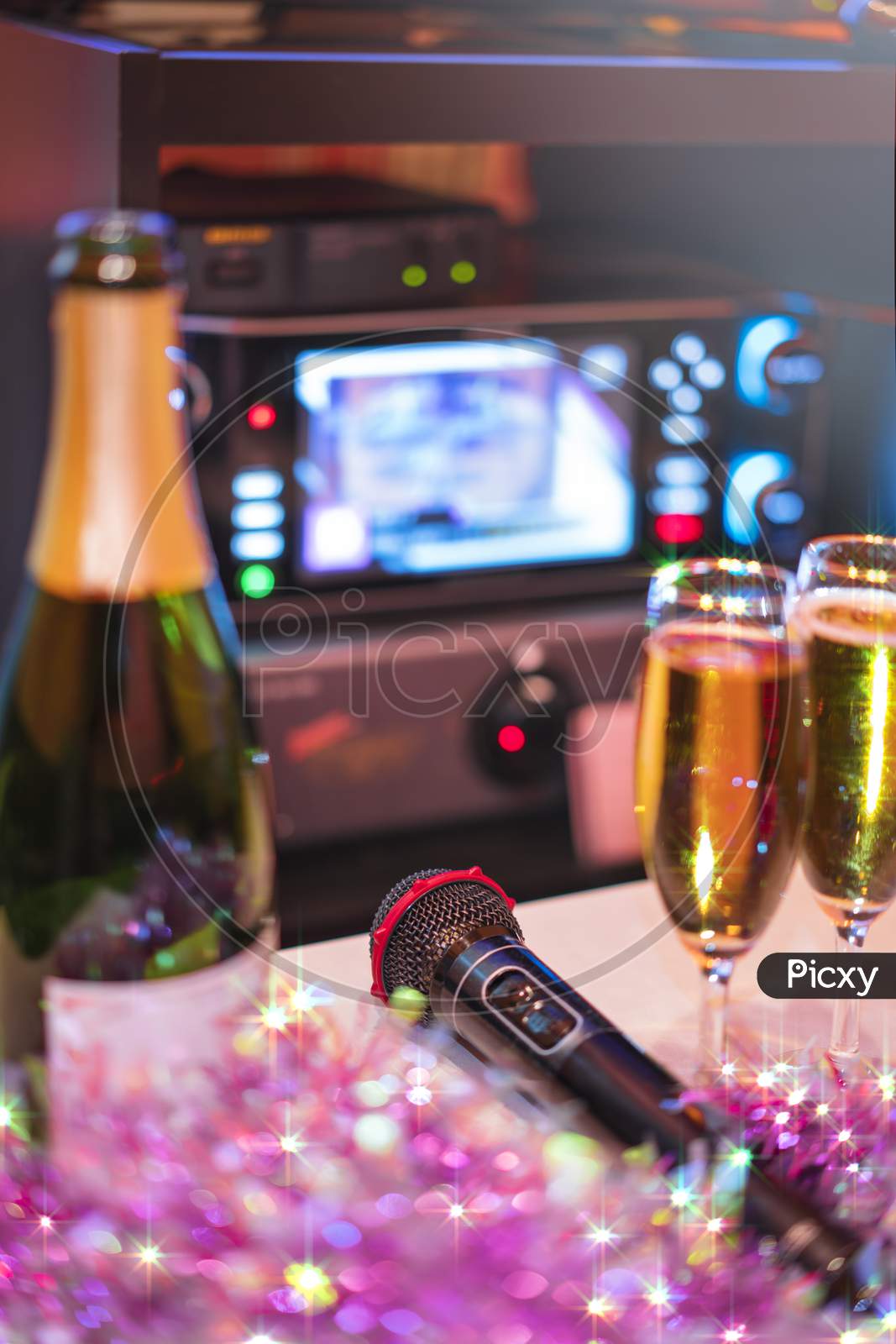 Black Microphone In Karaoke Club, With Remote Controller, Melon And Strawberry Soda Drinks, Yellow Tambourine And Screen For Singing Music On Stage Party.