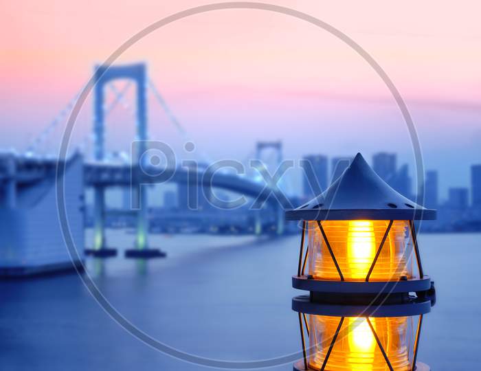 Lantern Of The Rainbow Bridge On The Bay Of Odaiba With Illuminations In Sunset Sky.