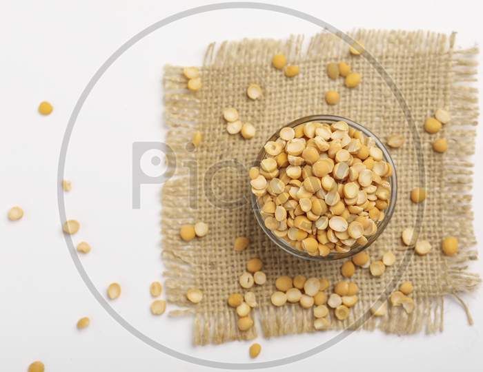 Dried Chickpea Lentils In Glass Bowl On White Background , Split Chickpea Also Know As Chana Dal ,