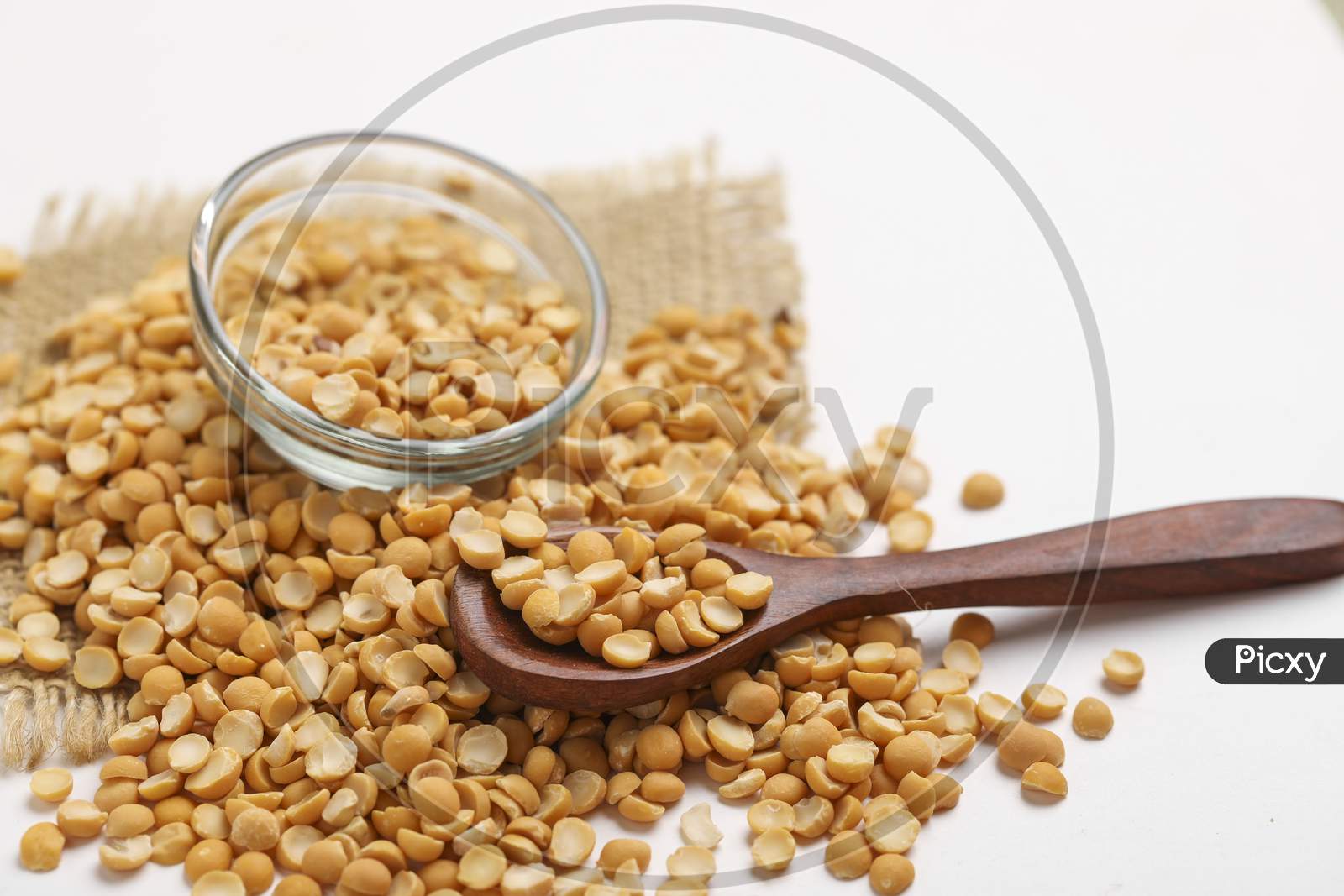 Dried Chickpea Lentils In Glass Bowl On White Background , Split Chickpea Also Know As Chana Dal ,