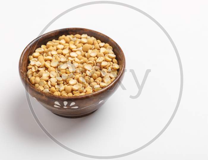 Dried Chickpea Lentils In Wooden Bowl On White Background , Split Chickpea Also Know As Chana Dal ,