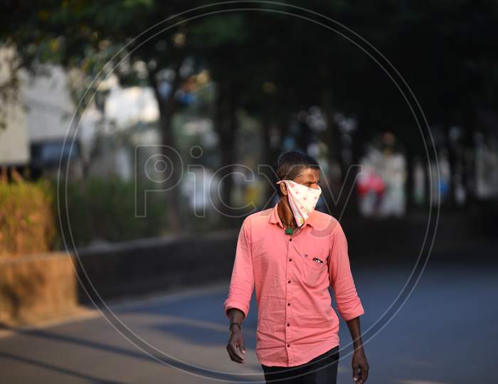 a man with a facemask carries milk before sunset during lockdown amid coronavirus pandemic