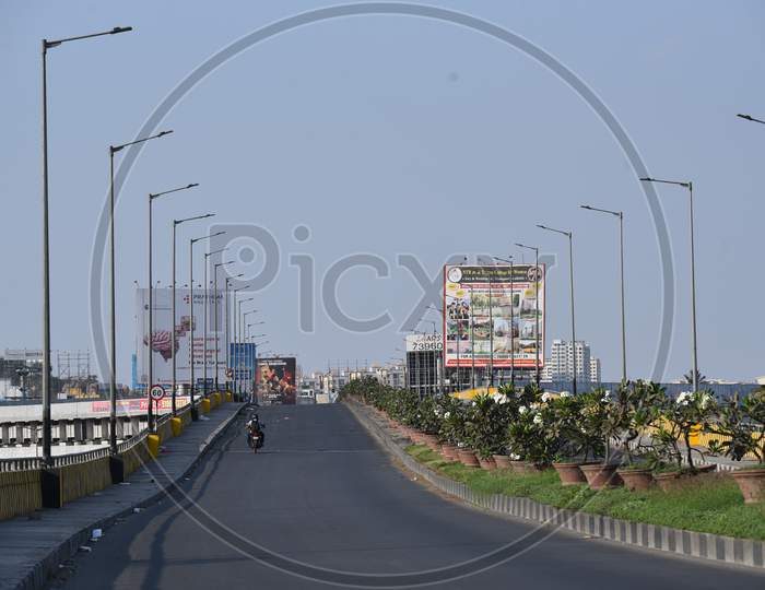 a man riding his two wheeler on a deserted flyover at Hitech City MMTS local railway station in Hyderabad amid lockdown due to coronavirus pandemic