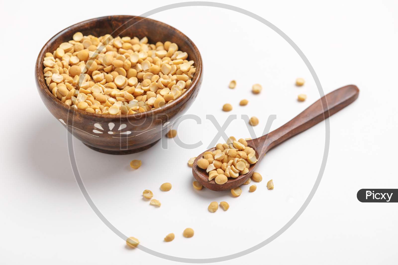 Dried Chickpea Lentils In Wooden Bowl And Spoon On White Background , Split Chickpea Also Know As Chana Dal ,