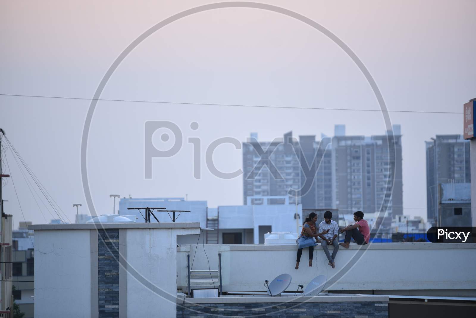 People sitting on their rooftops in the evenings to watch sunset to tackle the boredom due to the lockdown amid coronavirus outbreak
