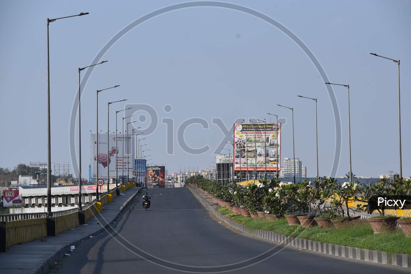 a man riding his two wheeler on a deserted flyover at Hitech City MMTS local railway station in Hyderabad amid lockdown due to coronavirus pandemic