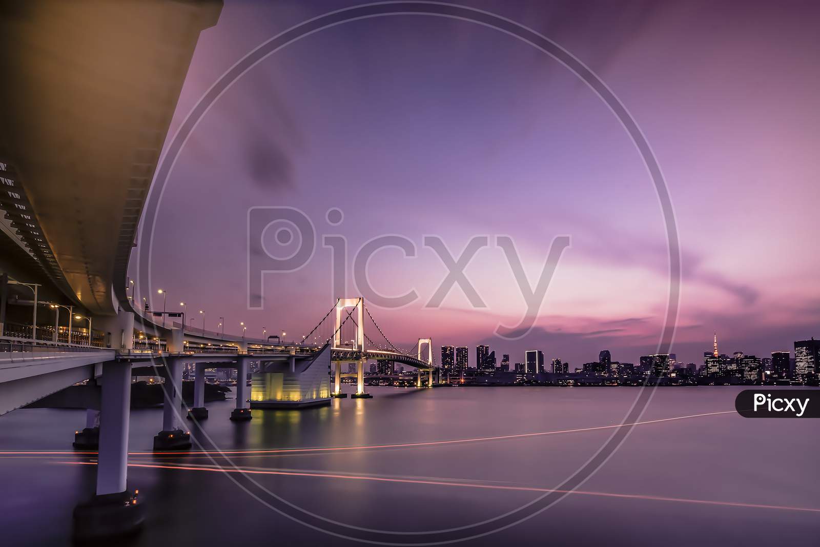 Long Exposure Photography Of Sunset On Rainbow Bridge And Tokyo Bay In Background.