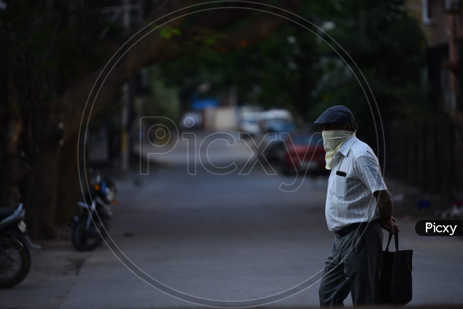 an elderly man steps out to buy groceries covers his face with a Hand Kercheif