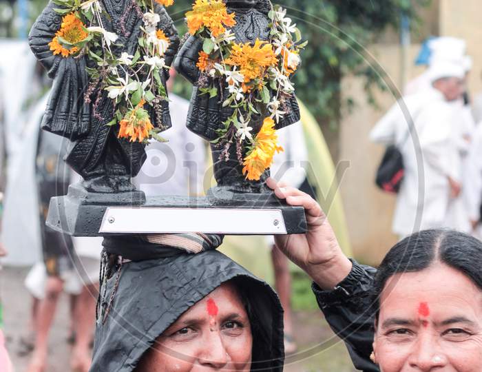 A Woman Carrying Deity Idols On Her Head