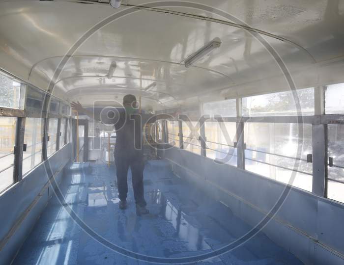 An employee being Entering Through a Bus made For Disinfectant Spraying  Due To Corona Virus Or COVID-19 Spread Eradication In Bangalore