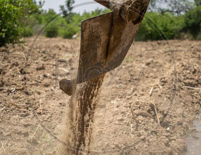 A farmer using a spade during irrigation