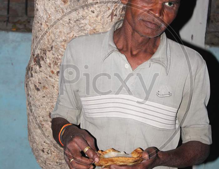 homeless poor man eating food in hand due to lockdown of covid-19, coronavirus.