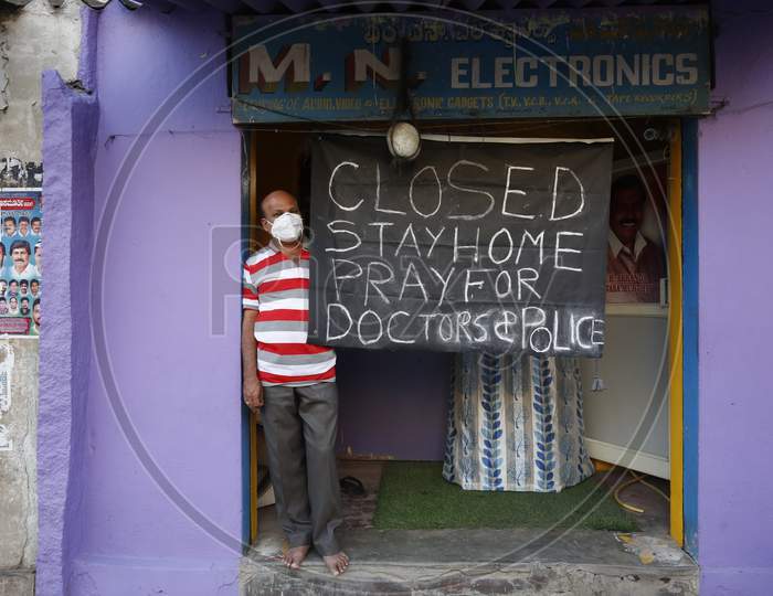 A Shopkeeper With A Shop Closed Board And Stay home Slogan on It during Corona Virus ( COVID-19) Pandemic Lockdown In Bengaluru