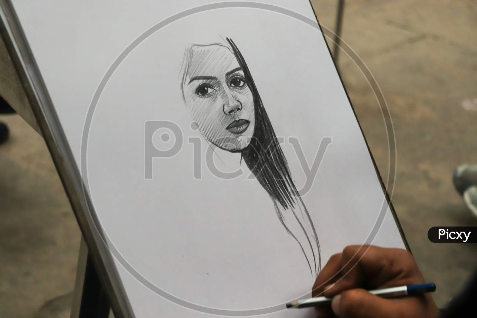 A Punjabi Boy Drawing A Sketch Of Beautiful Girl On White Paper With Pencil At Rock Garden, Uttar Marg, Rock Garden Of Chandigarh, Sector 1, Chandigarh